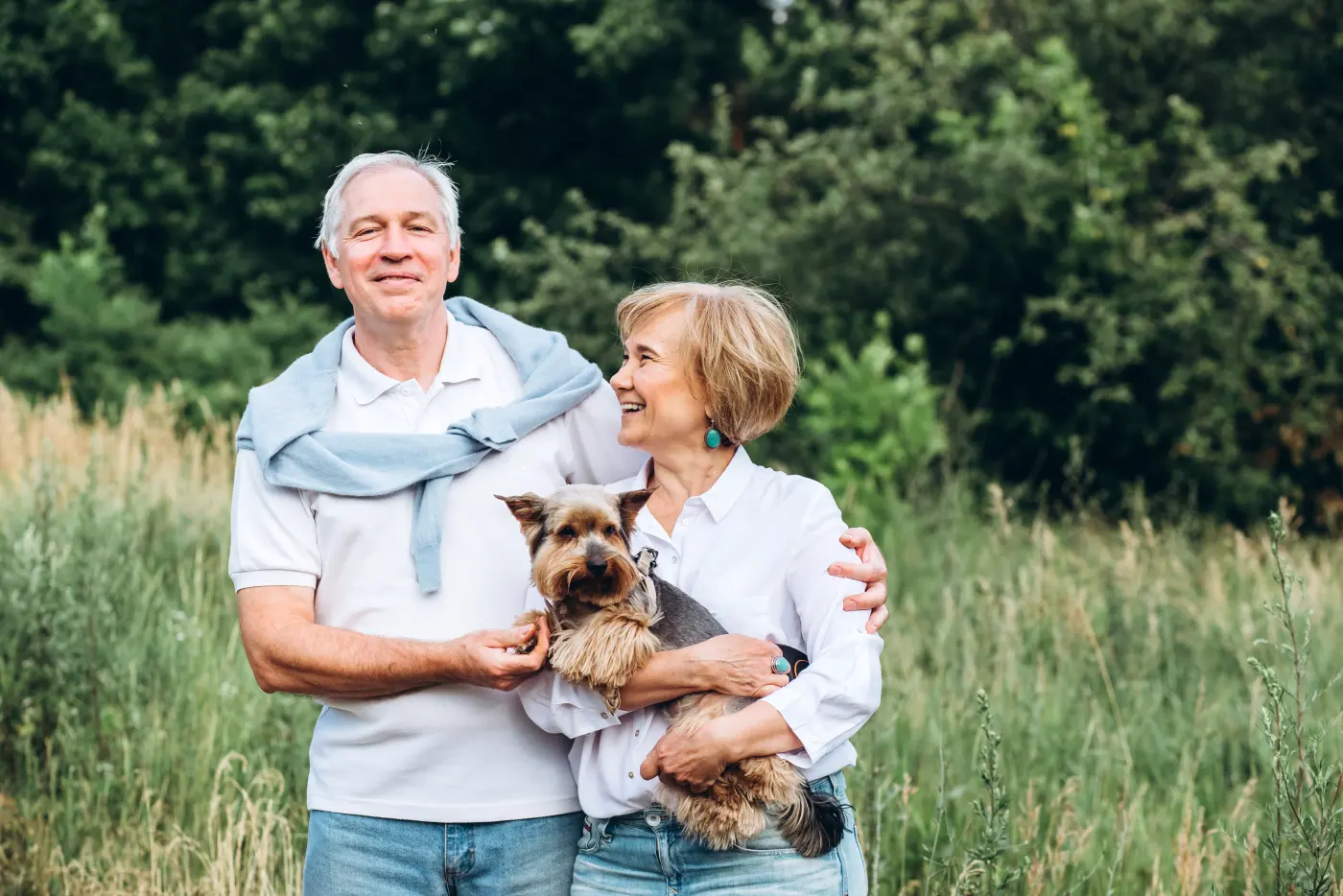 Älteres Paar mit Hund in der Natur